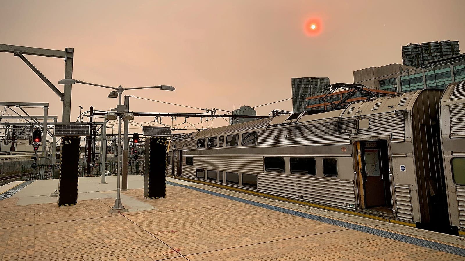 An orange, smoke-filled sky and a red sun over a Sydney railway station during the Black Summer fires
